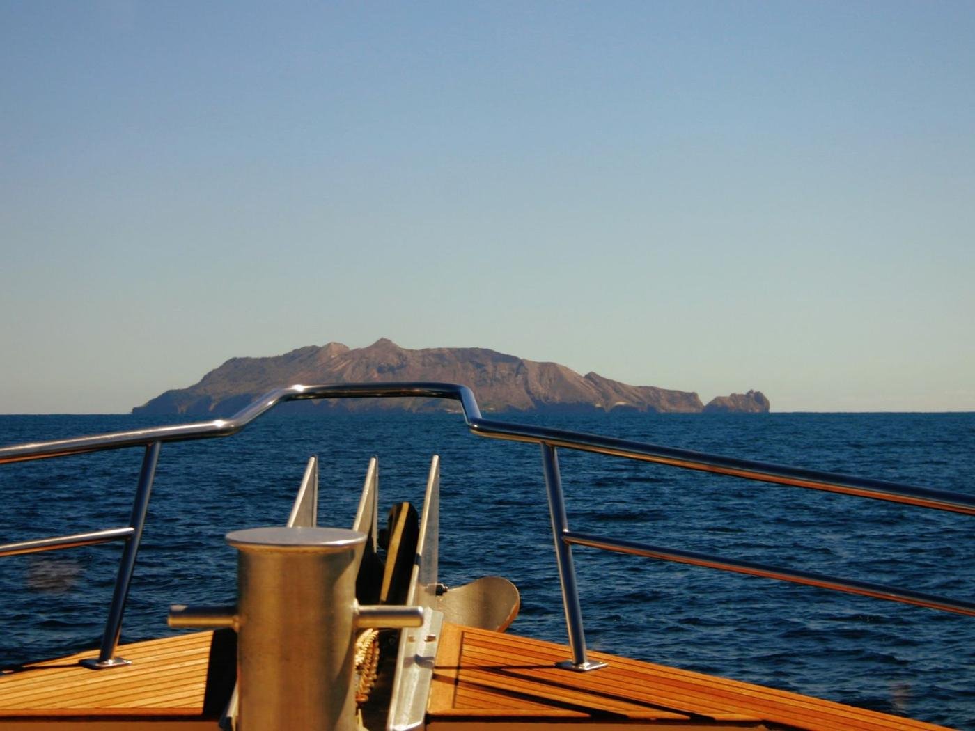 Proa de iate rumo a uma ilha em mar aberto